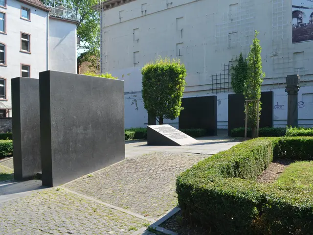 The image shows a garden with hedges and bushes in front of a building, surrounded by trees and a...