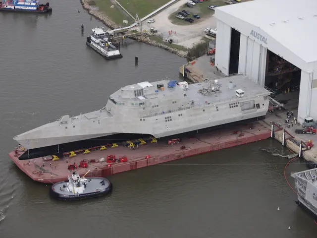 The image shows an aerial view of a large ship docked in the water near a dock, surrounded by other...