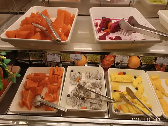 The image shows a buffet filled with a variety of different types of ice cream, including trays of...