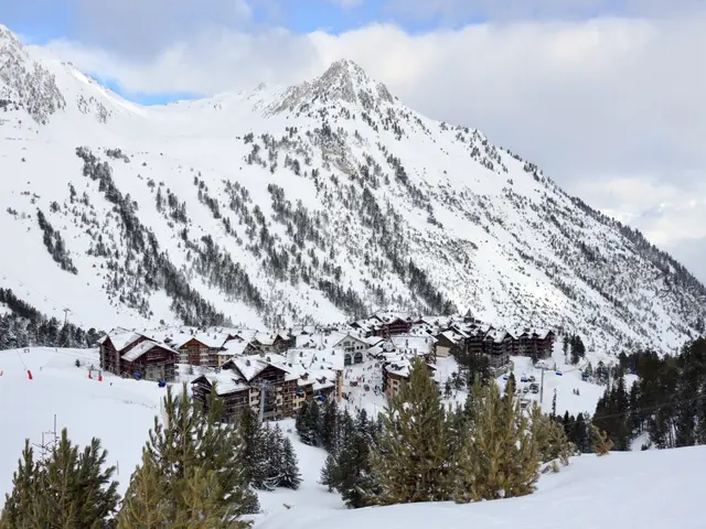 The image shows a picturesque winter scene of a ski resort with snow-covered mountains in the...
