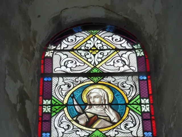 The image shows a stained glass window in a stone wall of a church. The window is composed of...