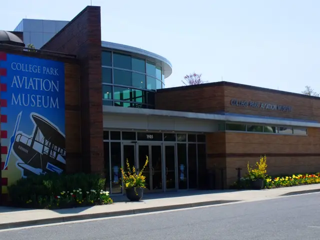 The image shows the College Park Aviation Museum, a building with glass walls and doors, a board...
