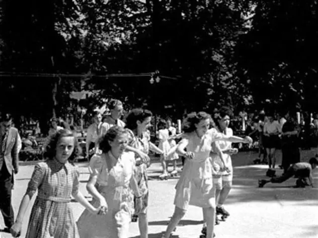 The image shows a group of young girls rollerblading in a park, surrounded by trees and other...