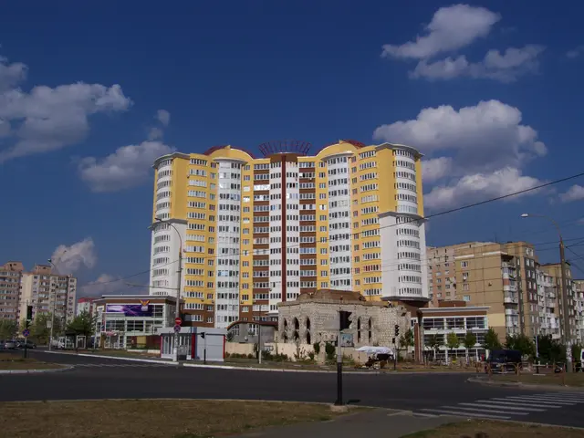 The image shows a large apartment building in the middle of a city, surrounded by street poles,...