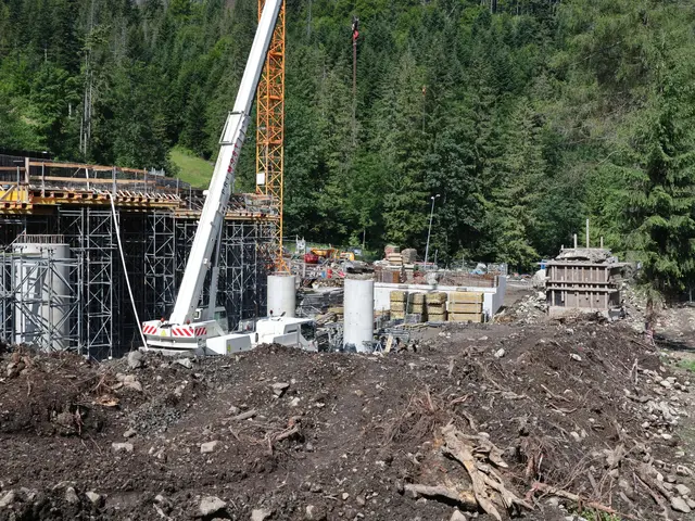 The image shows a construction site with a crane in the middle of it, surrounded by metal rods,...