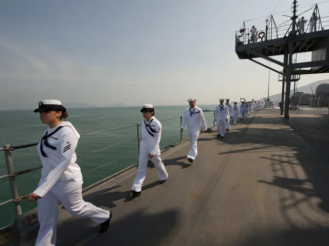 The image shows a group of sailors walking on the deck of a ship, wearing white uniforms and caps....