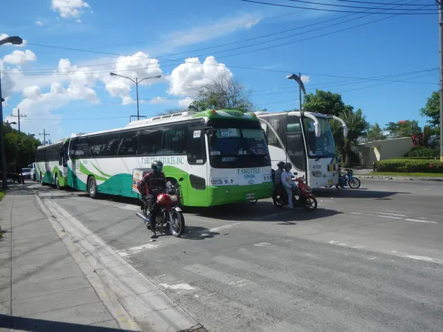 The image shows a green and white shuttle bus parked on the side of the road, with a few people...