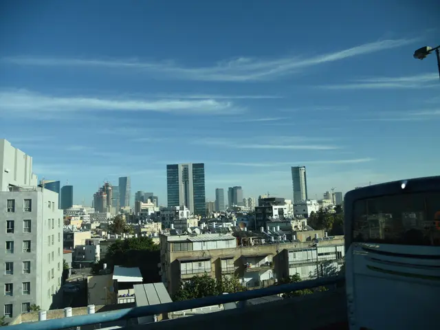The image shows a view of a city from the top of a building, with a bus on the right side of the...