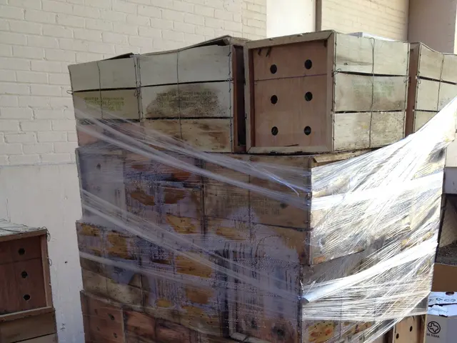 The image shows a pile of wooden boxes sitting on top of a sidewalk, with a wall on the right side...