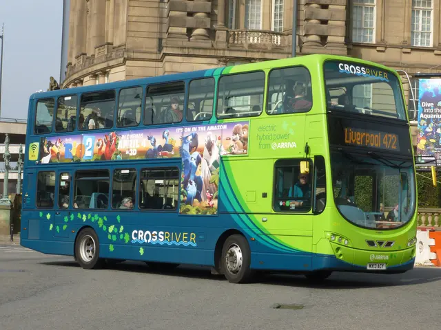 The image shows a green double decker bus driving down a street next to a tall building. Inside the...
