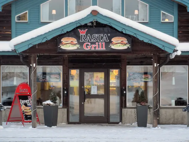 The image shows a building with glass windows and doors, a board with text and pictures of food...