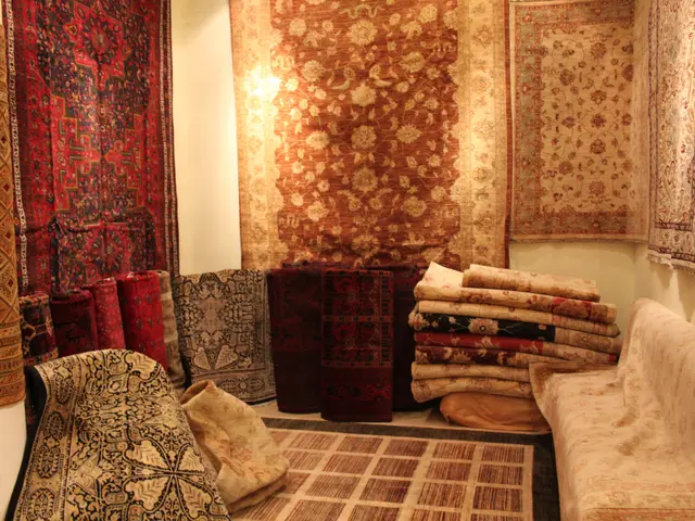 The image shows a room filled with lots of different types of carpets and rugs on the walls, as...