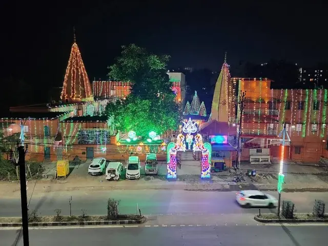 The image shows a city street at night illuminated by festive lights. There are vehicles on the...
