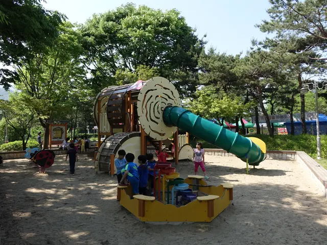 The image shows a group of children playing on a playground in a park. There is a slide in the...
