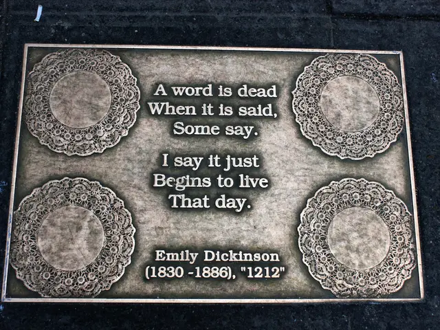 The image shows a plaque on the ground with a quote from Emily Dickinson that reads, "A word is...
