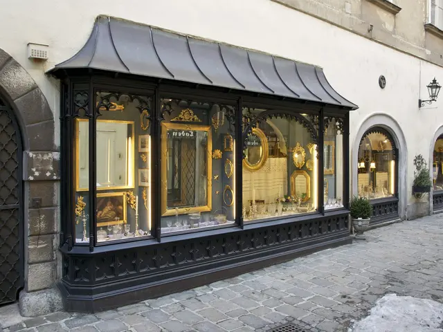 The image shows a store front with a black awning on the side of a street. The building has windows...