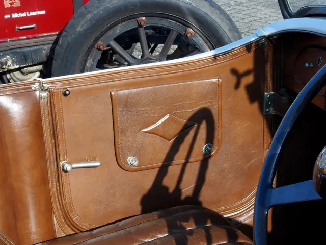 The image shows the interior of a vintage car with a brown leather seat, a steering wheel on the...