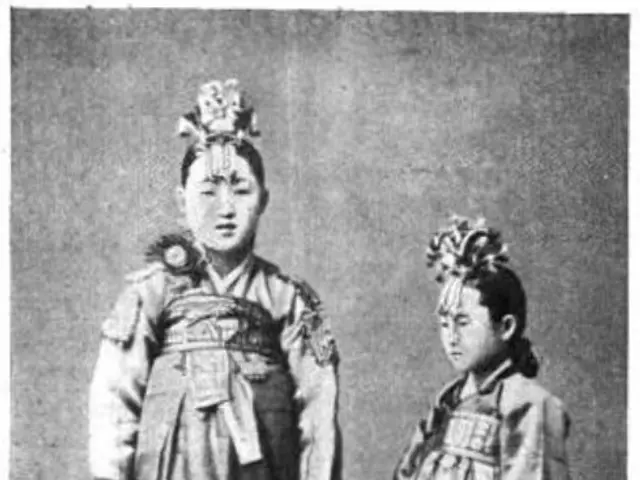 The image shows two women in traditional Korean clothing standing side by side. The image is in...