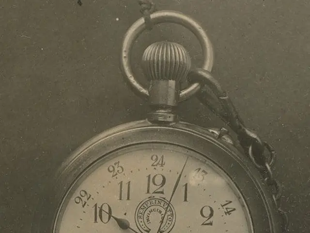 The image shows an old black and white photo of a pocket watch with a chain attached to it. The...