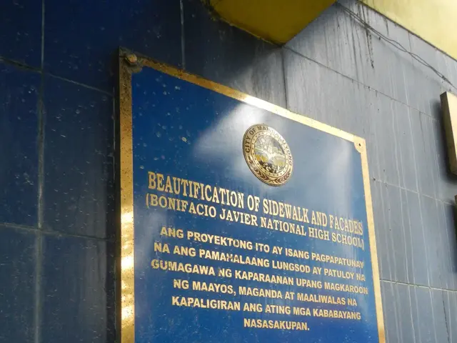 The image shows a blue plaque on the side of a building that reads "Beautification of Sidewalk and...
