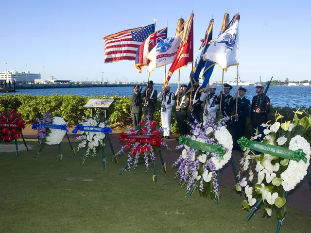 The image shows a group of people standing in front of a body of water, holding flags and wearing...