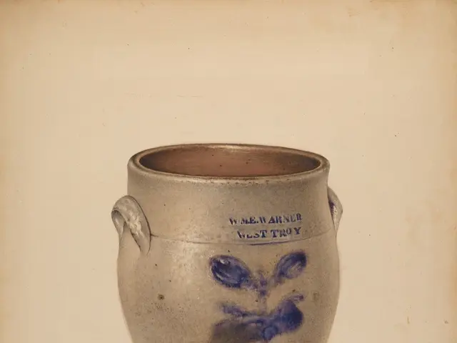 The image shows a stoneware crock with a blue and white design on it. The crock is made of ceramic...