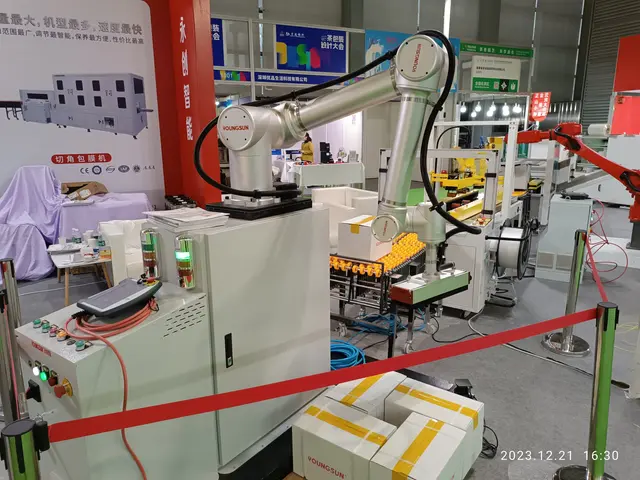 The image shows a group of robots sitting on top of a table, surrounded by machines, poles with...