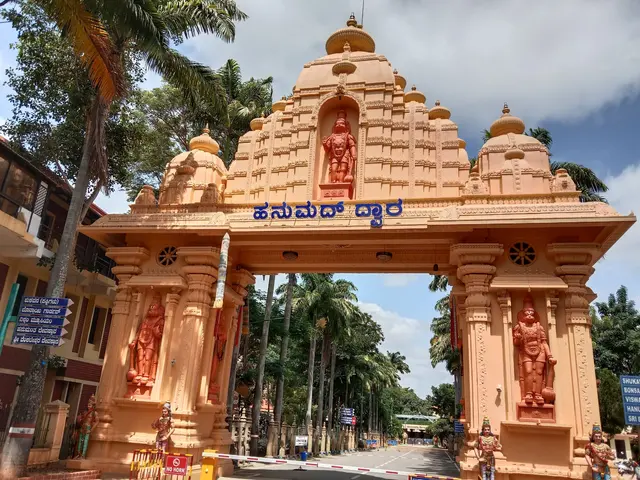 The image shows the entrance to a Hindu temple in Sri Lanka, with an arch adorned with sculptures...
