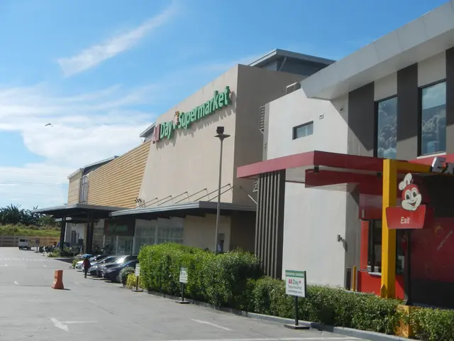 The image shows a grocery store with a parking lot in front of it, surrounded by buildings, street...