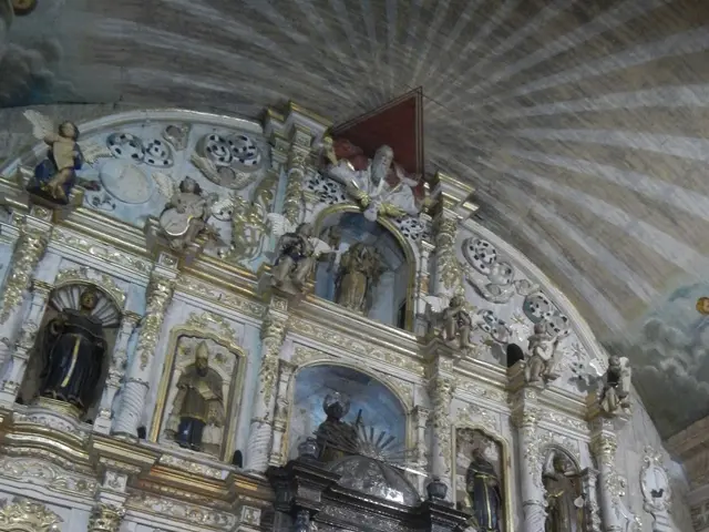 The image shows the interior of a church with many statues and flowers adorning the walls and...