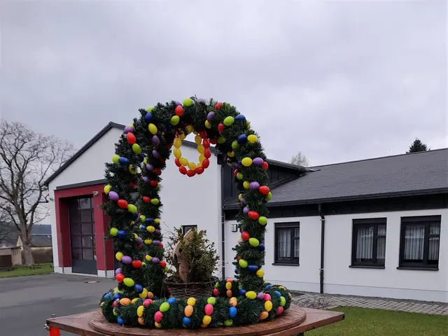 The image shows a festive scene with a large wreath made out of colorful balls sitting atop a green...