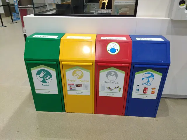 The image shows a row of four colorful trash cans sitting next to each other on the floor. In the...
