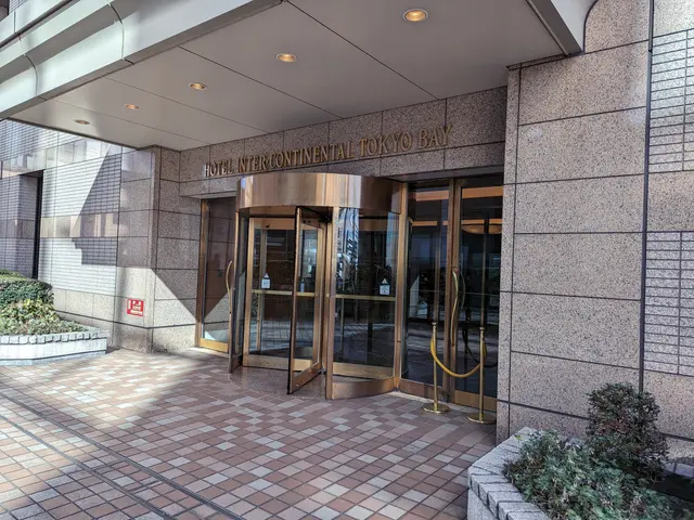 The image shows the entrance to the Intercontinental Tokyo Bay Hotel, with its glass doors and text...