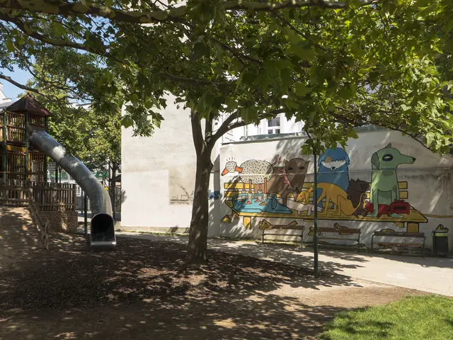 The image shows a park with a playground featuring a slide and a mural on the wall. There are...