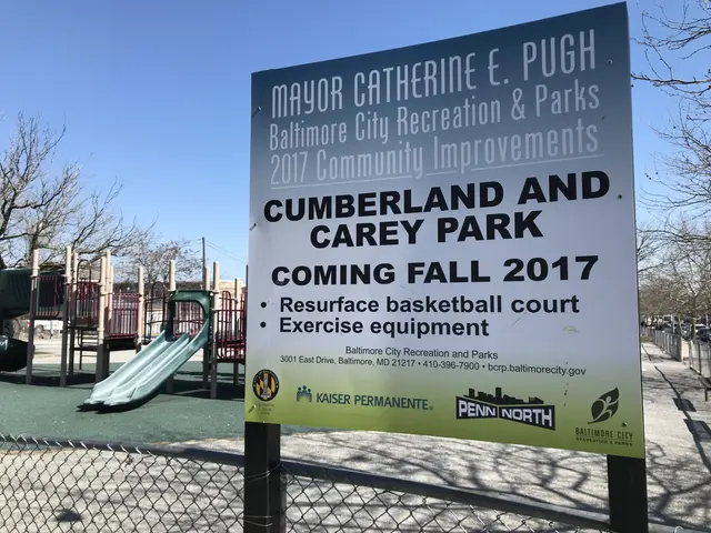 The image shows a board attached to a pole with a sign that reads "Cumberland and Carey Park Coming...