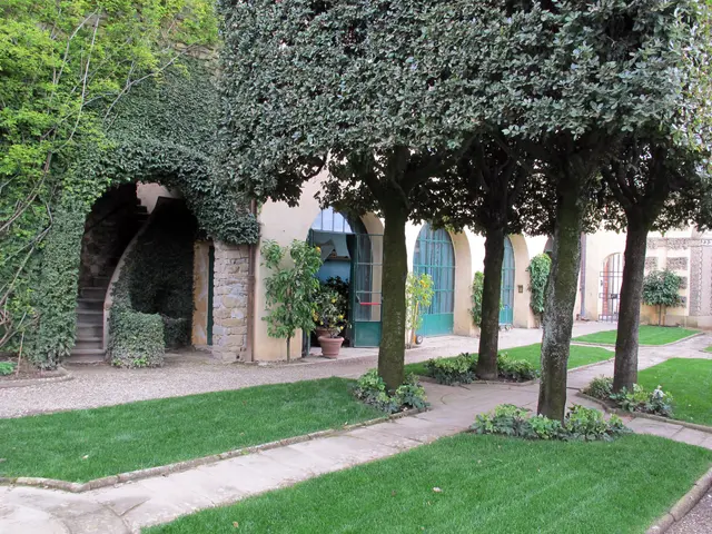 The image shows a garden with lush green grass, trees, and plants, as well as a path leading to a...